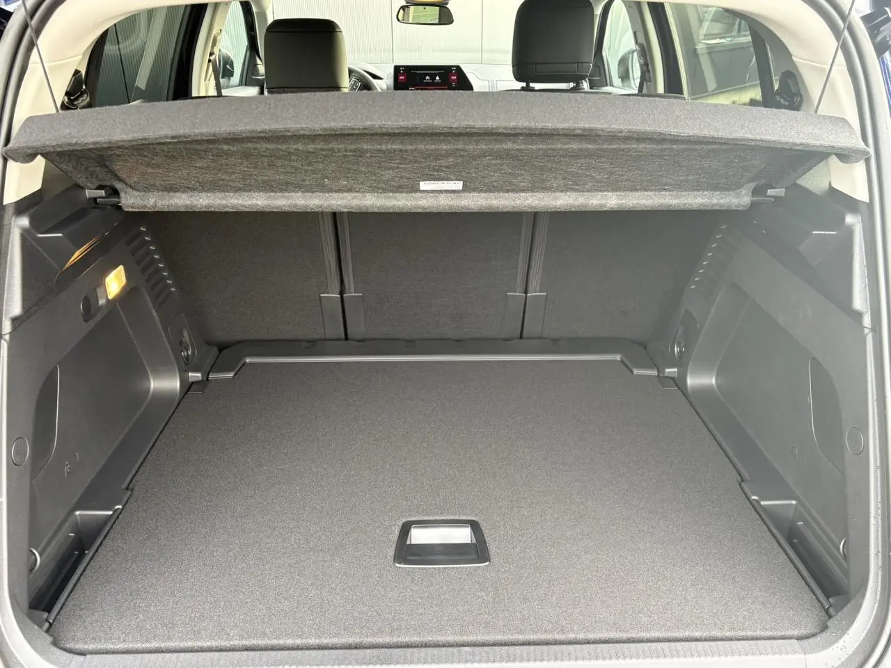 Vue intérieure du coffre ouvert du Citroën C5 Aircross Noir Perla, montrant la tablette de séparation et les sièges arrière.