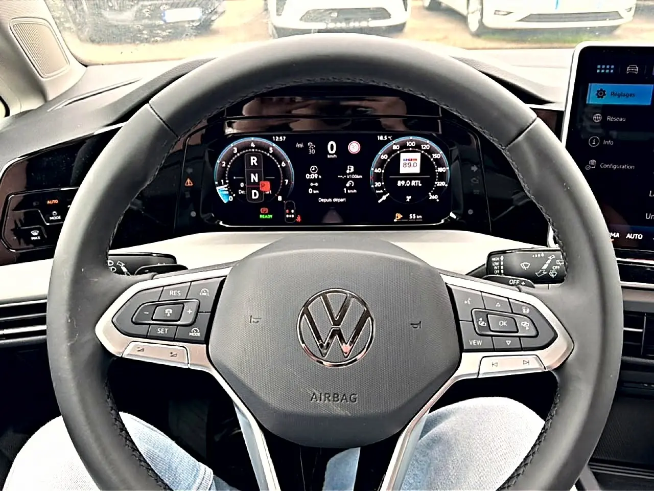 Vue intérieure centrée sur le volant noir de la Volkswagen Golf 2026 avec tableau de bord digital et commandes intégrées.