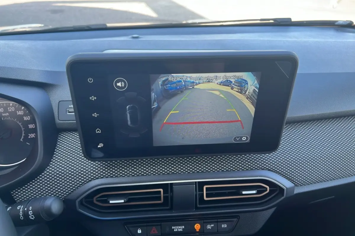 Vue intérieure du tableau de bord de la Dacia Sandero Stepway 2025, écran affichant la caméra de recul et aérateurs centraux.