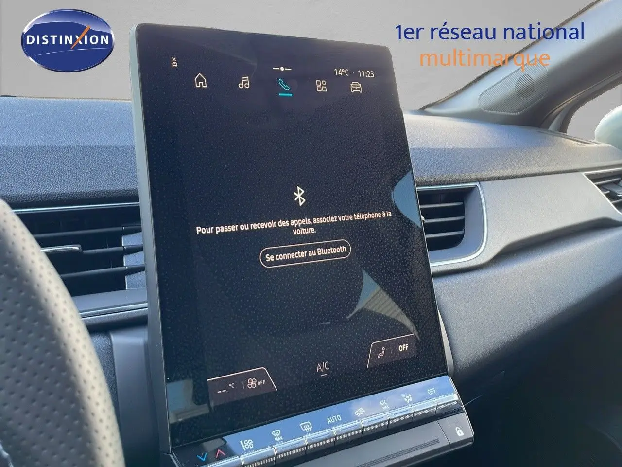 Écran tactile central allumé dans l’habitacle du Renault Captur blanc nacré avec toit gris, vue côté passager.