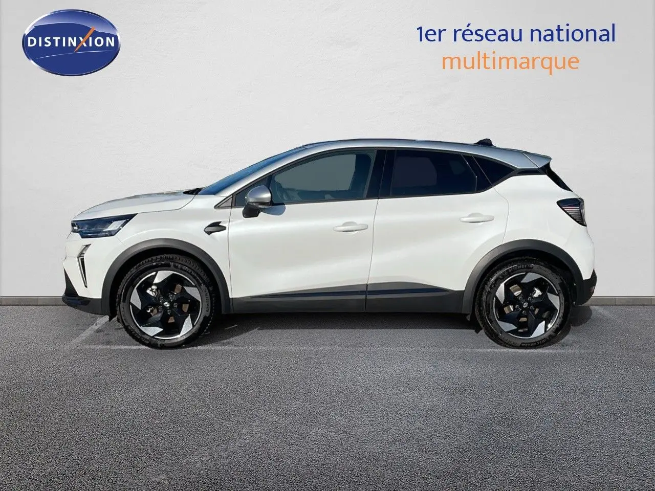 Profil côté gauche d'un Renault Captur E-Tech hybride 2025 blanc nacré avec toit gris et jantes noires distinctives.