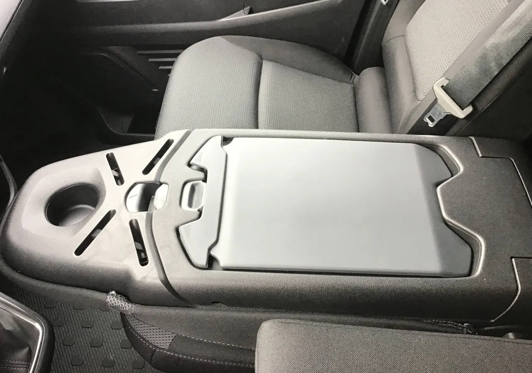 Vue rapprochée de la console centrale noire et des sièges gris du Renault Trafic Fourgon L1H1 2025 côté passager.
