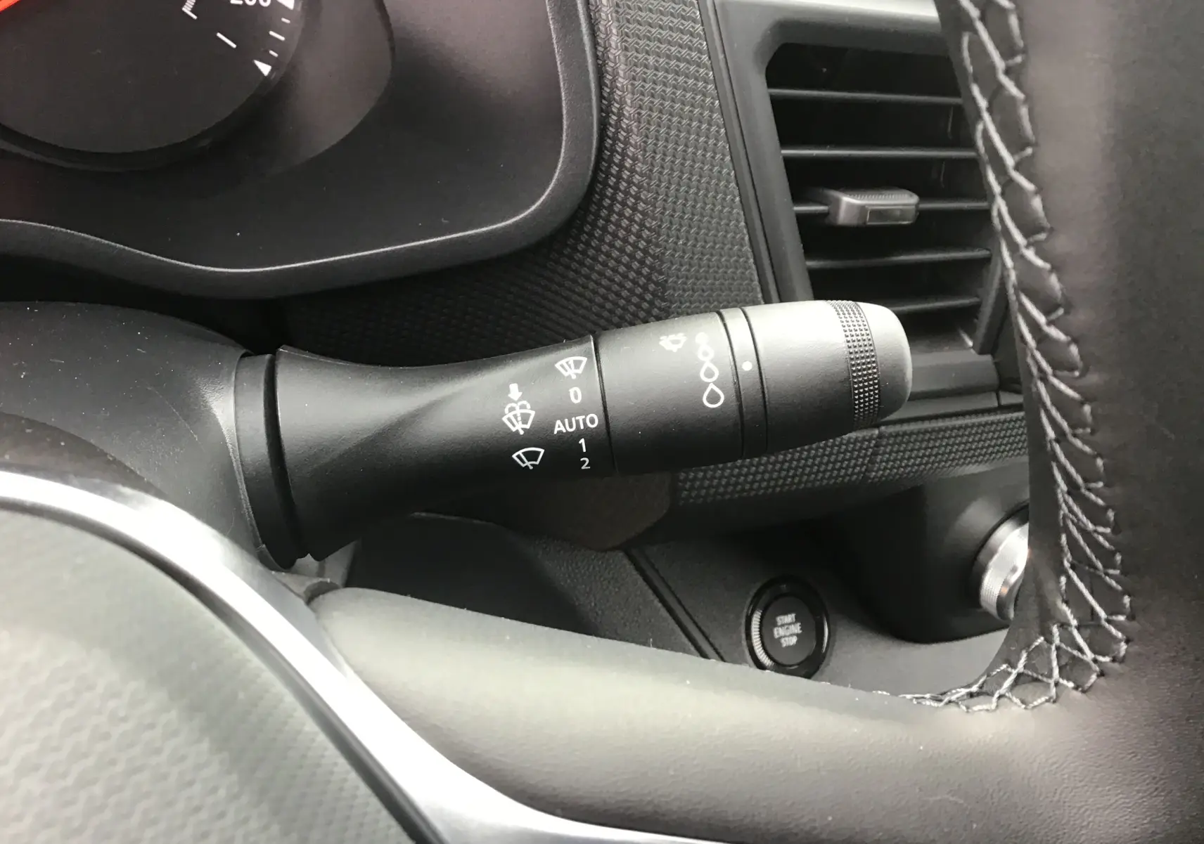 Gros plan sur la commande des essuie-glaces à gauche du volant du Renault Trafic Fourgon noir, avec bouton start visible.