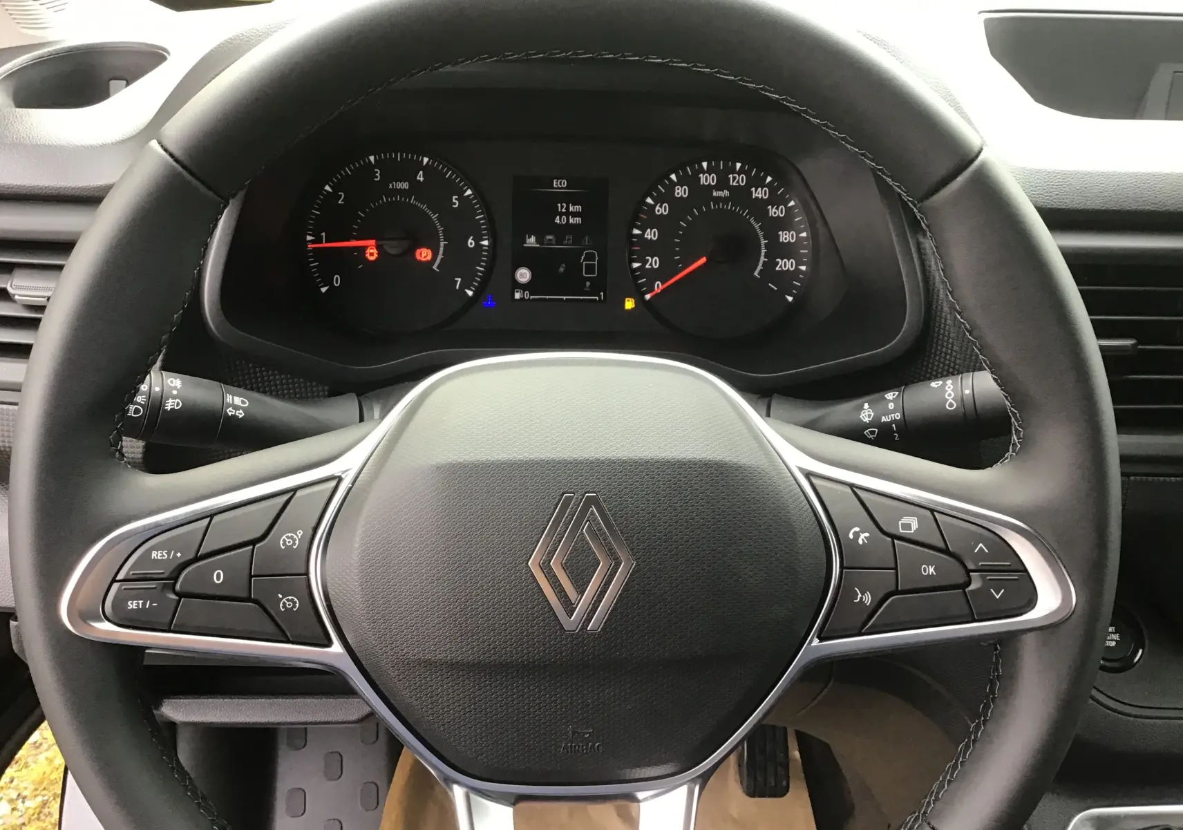 Vue rapprochée du volant noir du Renault Trafic Fourgon 2025 avec commandes intégrées et tableau de bord digital.