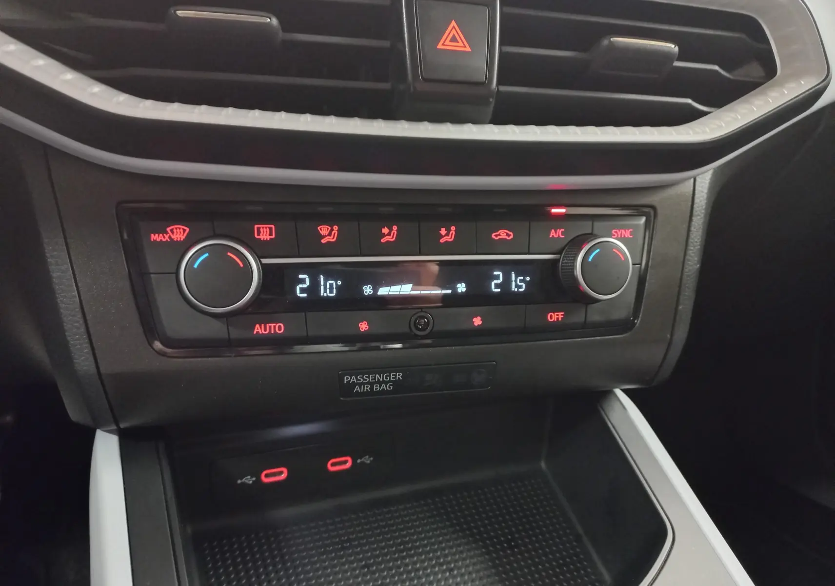 Gros plan sur la console centrale du SEAT Arona 2025, montrant la climatisation digitale et les ports USB.