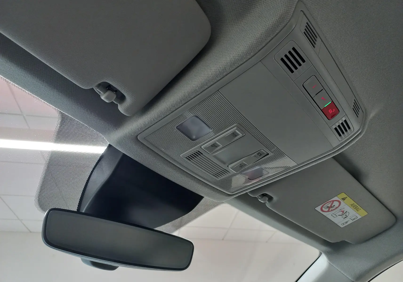 Vue intérieure du plafond avant de la SEAT ARONA 2025, avec commandes d’éclairage et rétroviseur central.