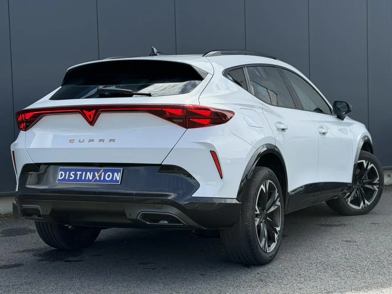 Vue 3/4 arrière droite du CUPRA Formentor blanc Neige avec signature lumineuse Tri-LED et jantes alliage 18 pouces.