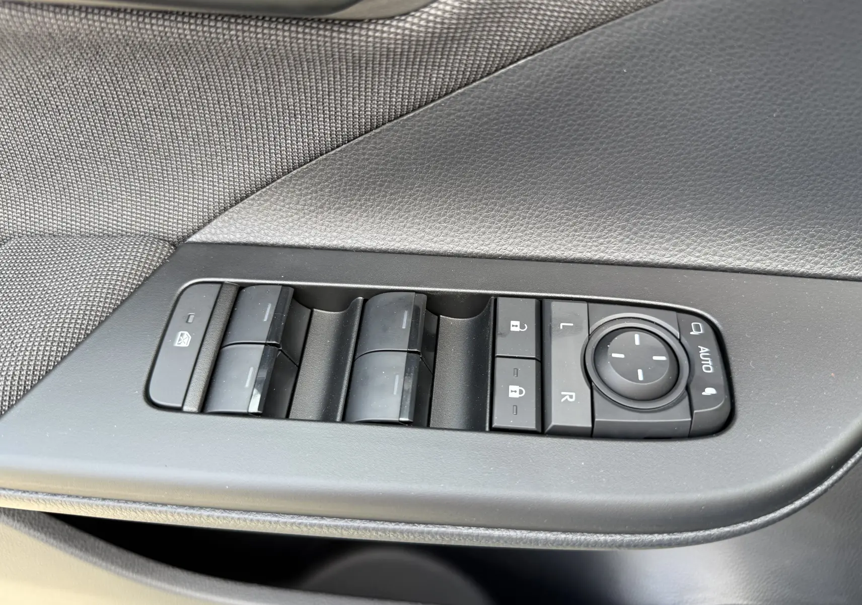 Panneau de commandes des vitres et rétroviseurs côté gauche intérieur du Toyota C-HR gris atlas 2025.