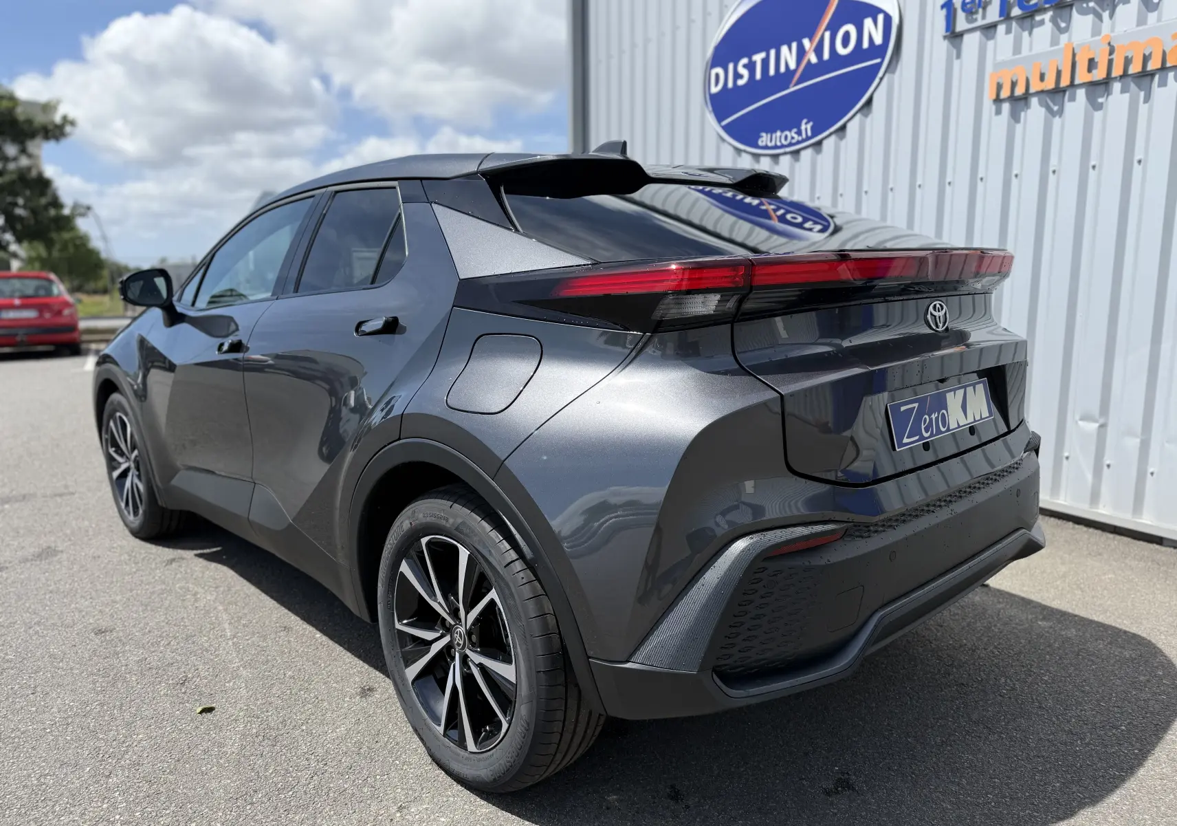 Vue 3/4 arrière droite du Toyota C-HR 1.8 Hybride 140 Style gris atlas avec feux arrière LED et jantes alliage noires.
