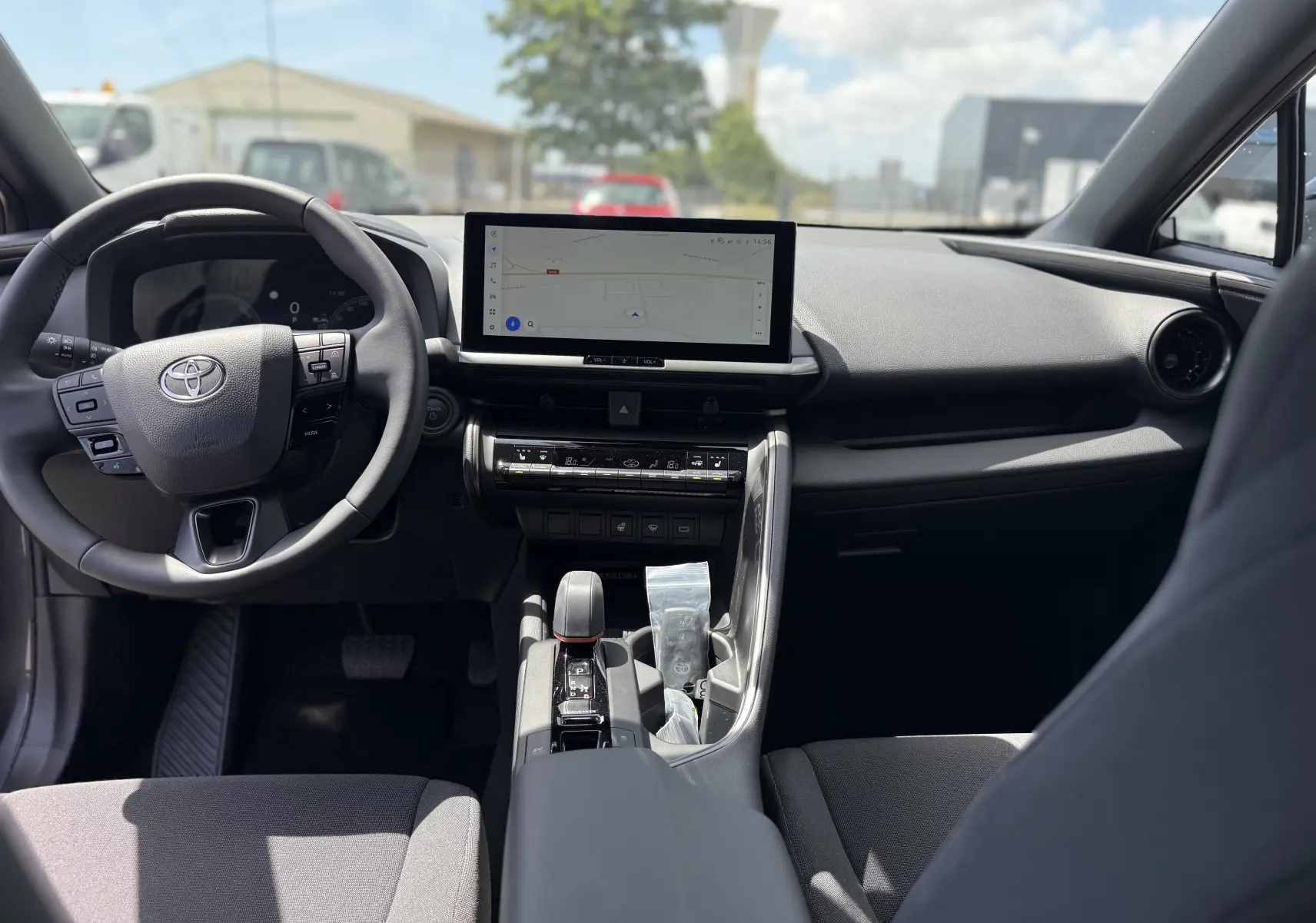 Intérieur du Toyota C-HR 1.8 Hybride 140 Style 2025, vue frontale du tableau de bord avec écran tactile et volant multifonction.