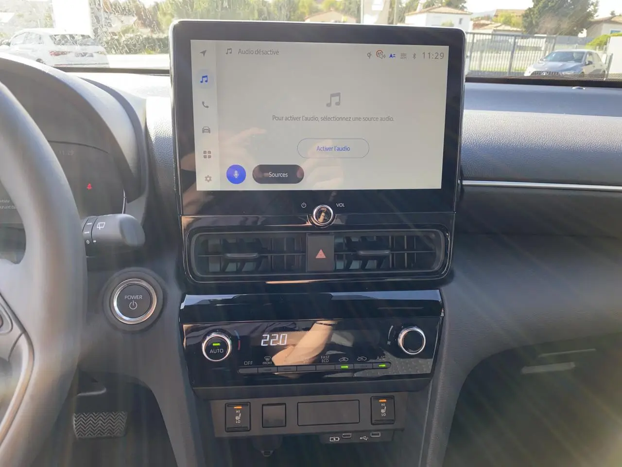 Vue rapprochée du tableau de bord de la Toyota Yaris Cross 2025 avec écran tactile et commandes climatisation.