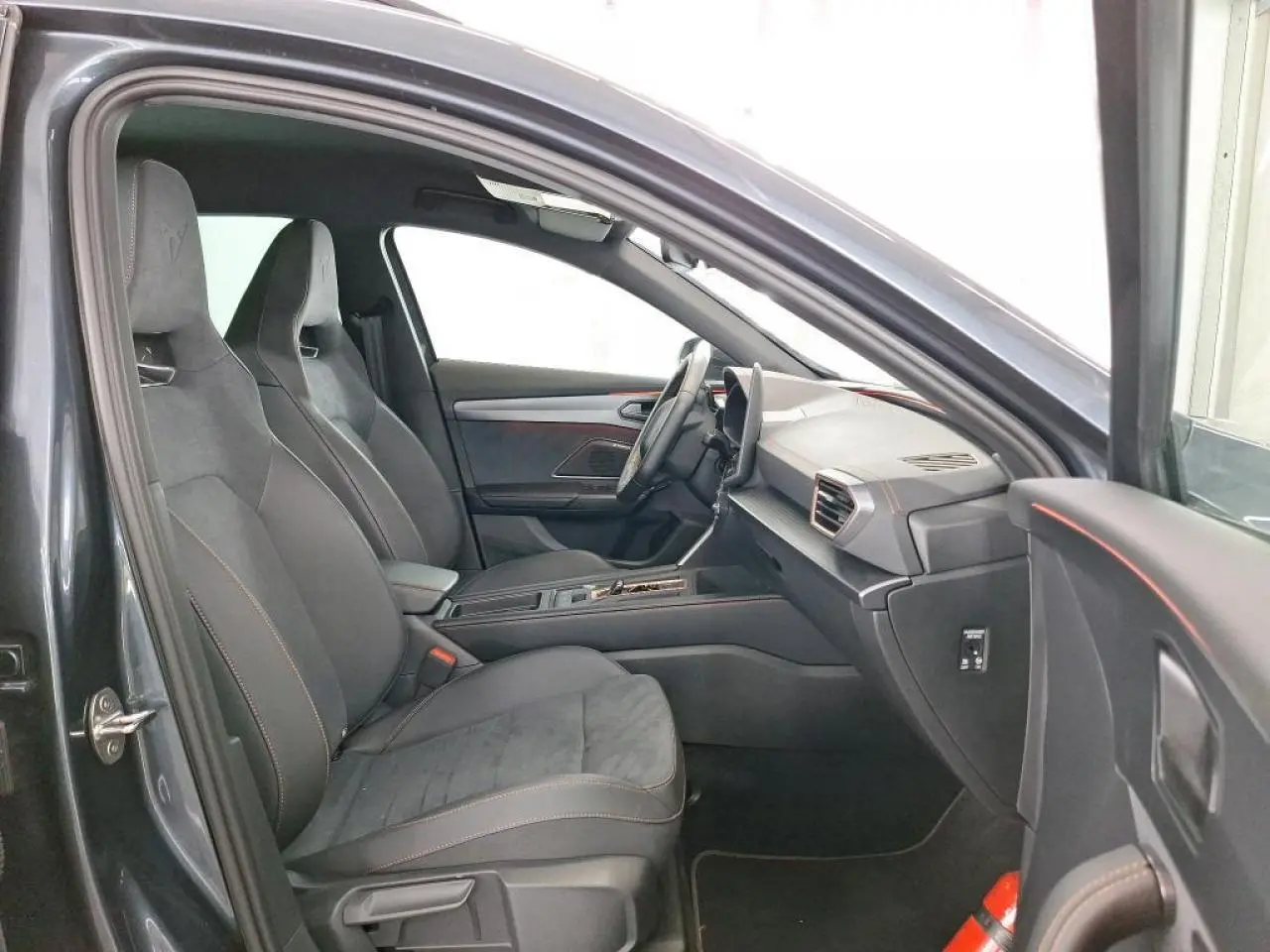 Intérieur de la CUPRA Formentor 2024 en gris, vue côté gauche montrant sièges baquets suédine noirs et tableau de bord moderne.