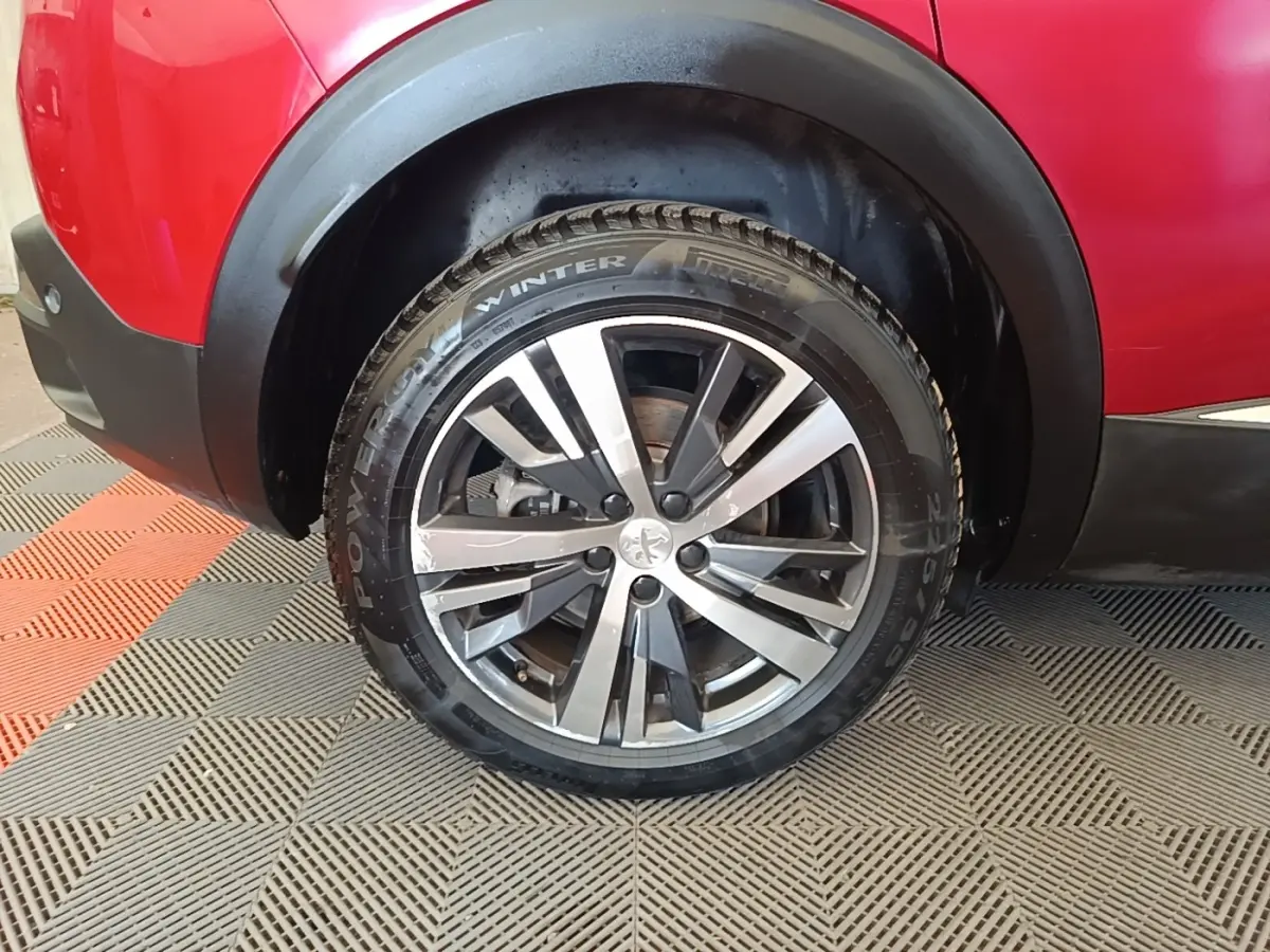 Gros plan sur la roue arrière gauche du Peugeot 3008 rouge, avec jante alliage et pneus hiver Pirelli.