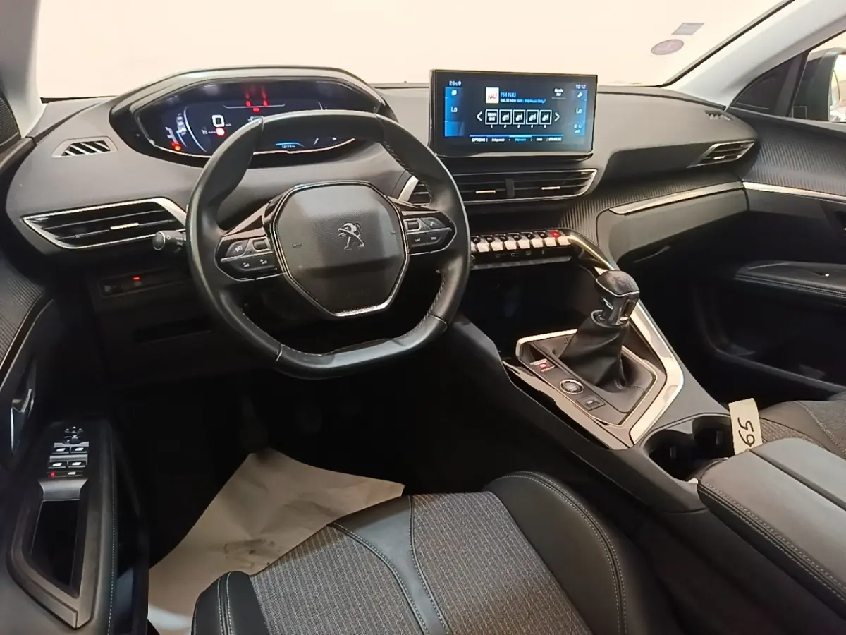 Intérieur noir du Peugeot 3008 PureTech 130 S&S Allure 2021, vue de face sur le volant, tableau de bord et écran tactile central.