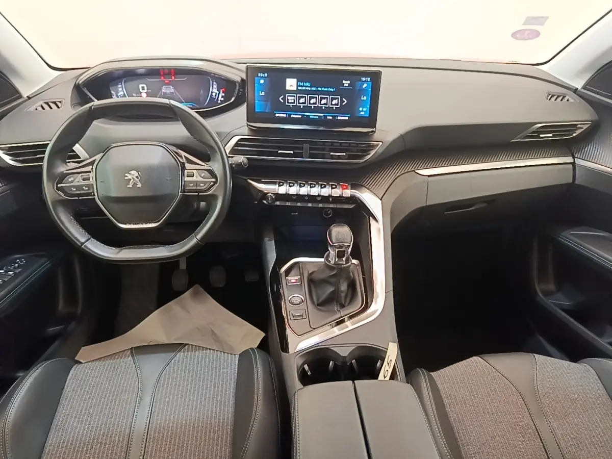 Vue intérieure avant du Peugeot 3008 PureTech 130 S&S Allure 2021, tableau de bord noir avec écran tactile central et volant cuir.