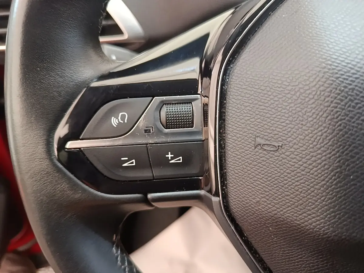 Gros plan sur le côté gauche du volant noir du Peugeot 3008 PureTech 130 S&S Allure, avec commandes intégrées.