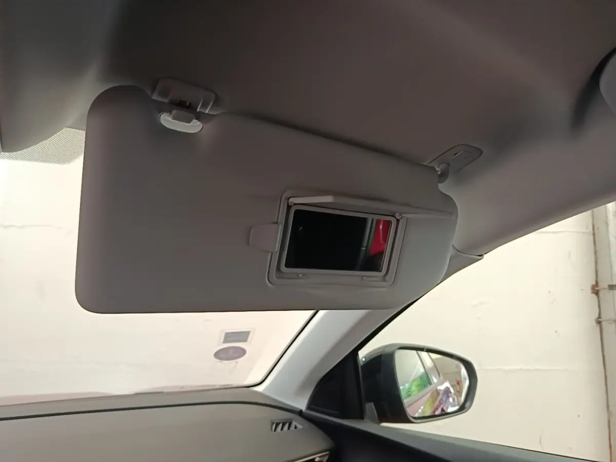 Détail intérieur du pare-soleil côté conducteur avec miroir et rétroviseur extérieur noir visible sur Peugeot 3008.