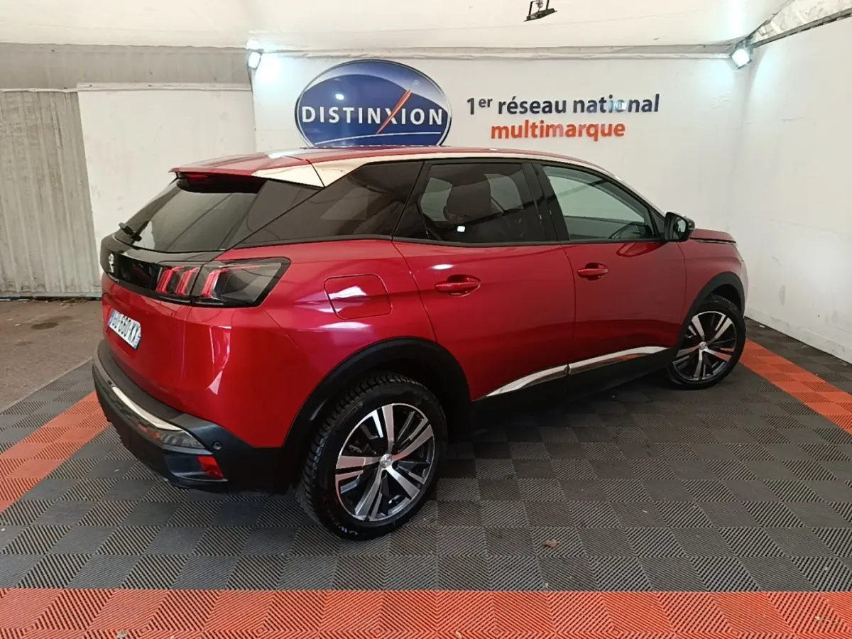 Peugeot 3008 rouge vue 3/4 arrière droit dans un garage avec toit noir et vitres teintées.