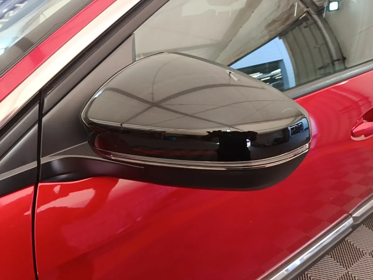 Rétroviseur extérieur droit noir brillant sur Peugeot 3008 rouge, vue rapprochée côté avant droit.