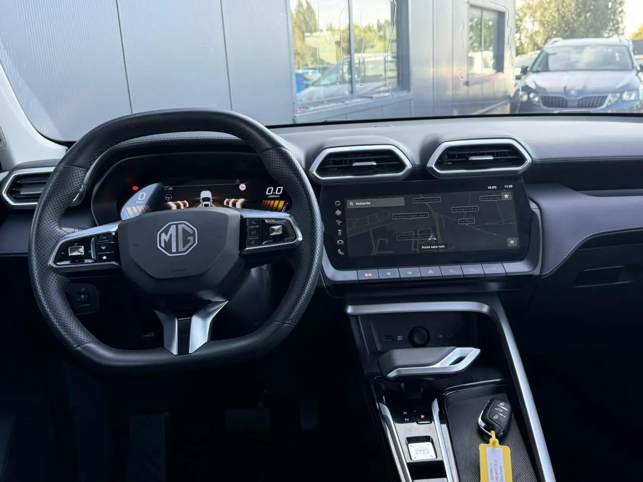 Vue intérieure du tableau de bord et volant du MG ZS 1.5 Hybrid+ 197 Luxury avec écran tactile et clé posée sur la console.
