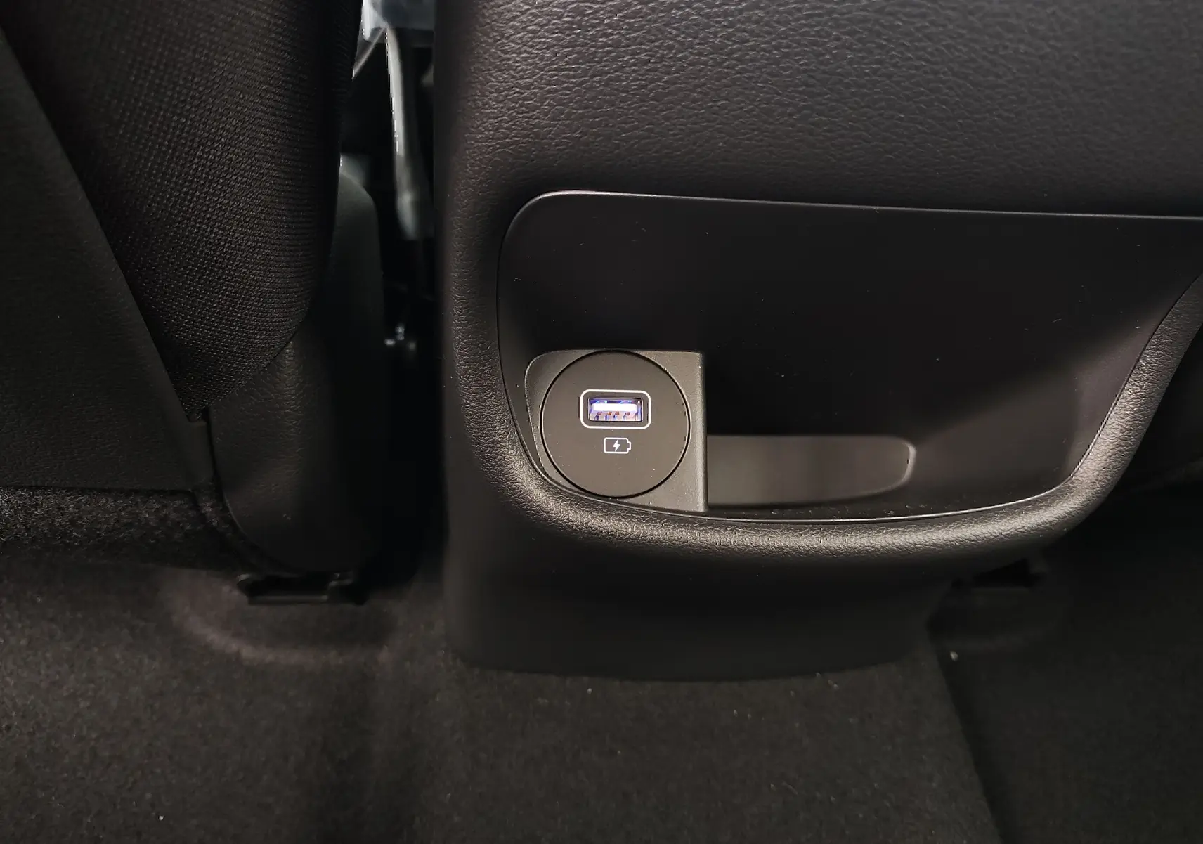 Prise USB de recharge arrière intégrée dans la console centrale noire du Hyundai Kona Electric gris métallisé 2025.