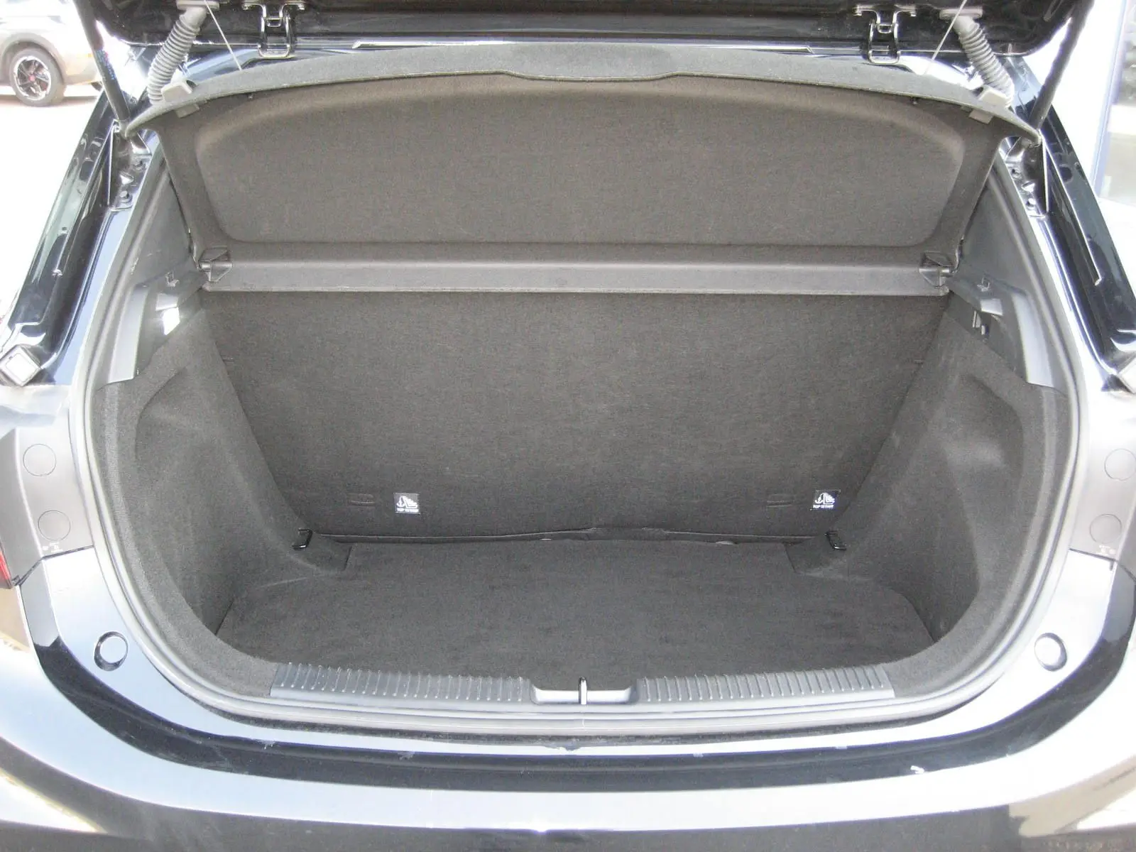 Coffre ouvert vu de l'arrière d'une MG MOTOR MG3 noire 2024, montrant un espace de chargement propre et vide.