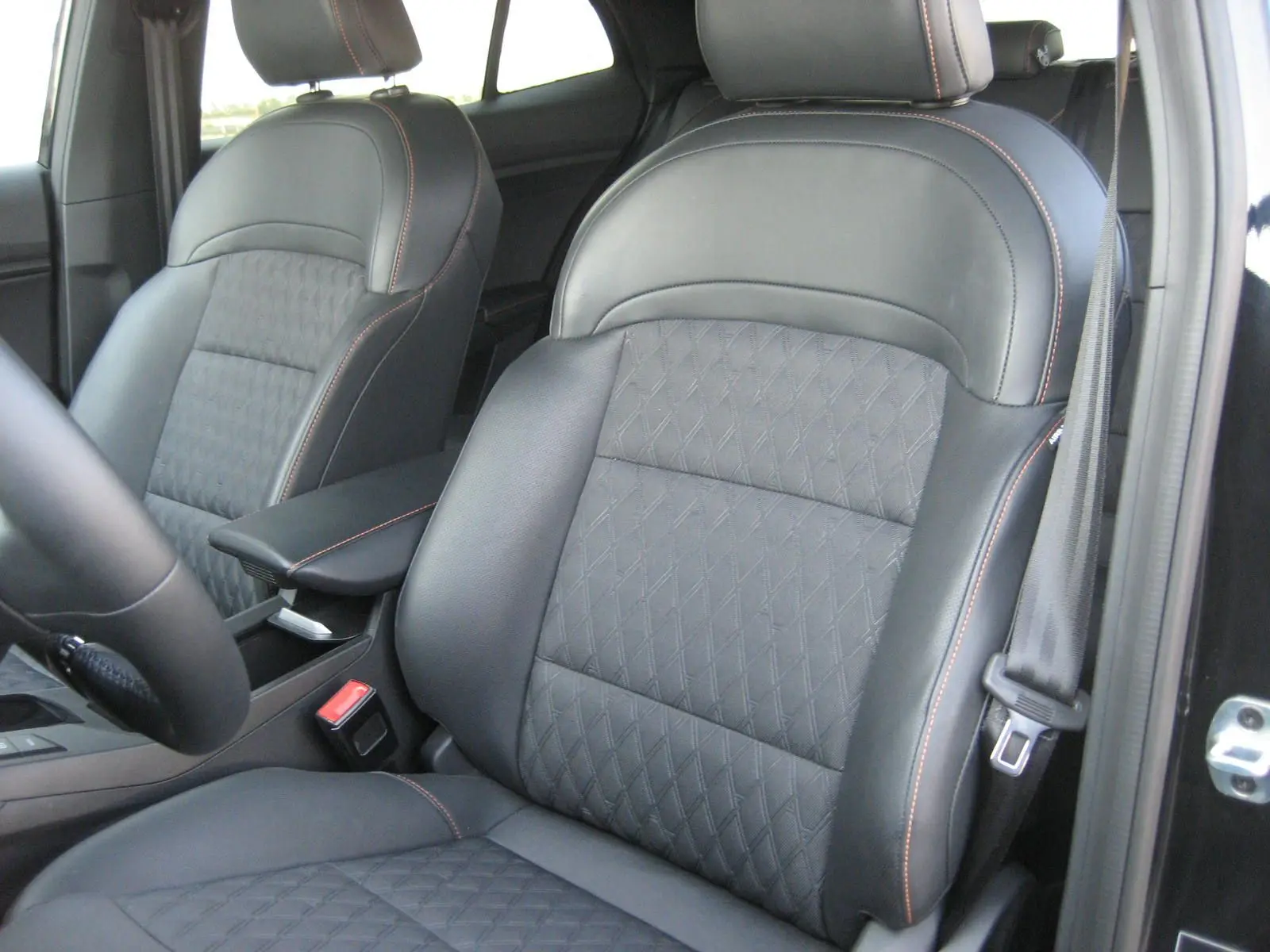 Gros plan sur les sièges avant en cuir noir avec surpiqûres orange de la MG3 1.5 HYBRID+ 195 CH LUXURY 2024.