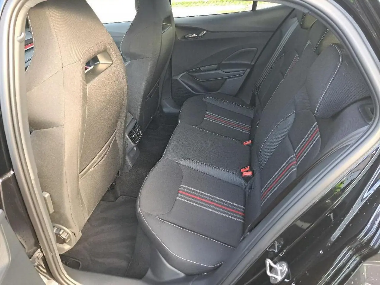 Vue intérieure côté droit des sièges arrière noirs avec surpiqûres rouges et grises d'une Skoda Fabia Monte Carlo 2024.