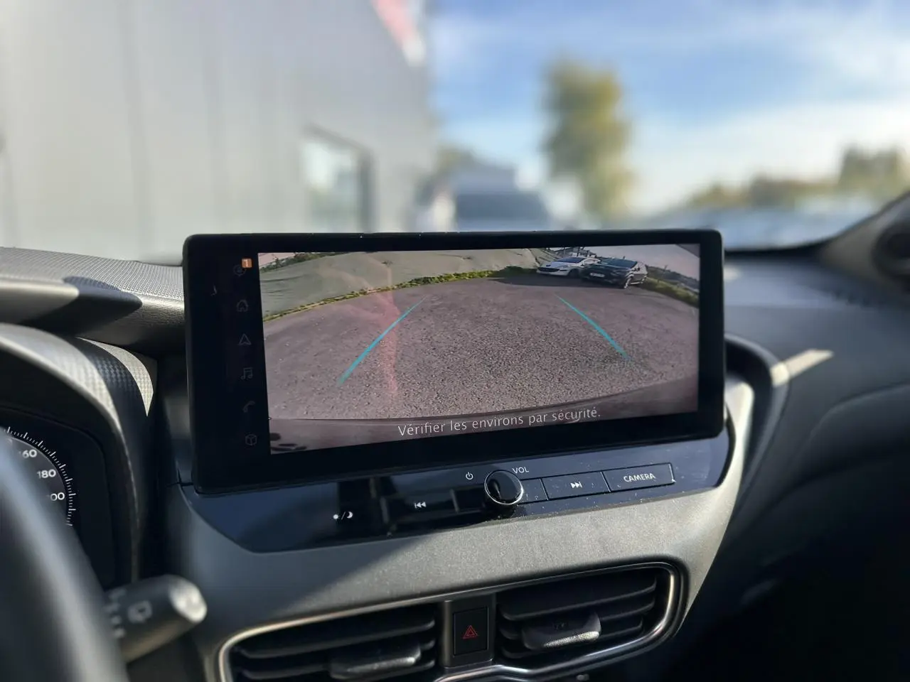 Vue intérieure centrée sur l'écran tactile affichant la caméra de recul du Nissan Juke noir 2025 avec tableau de bord moderne.