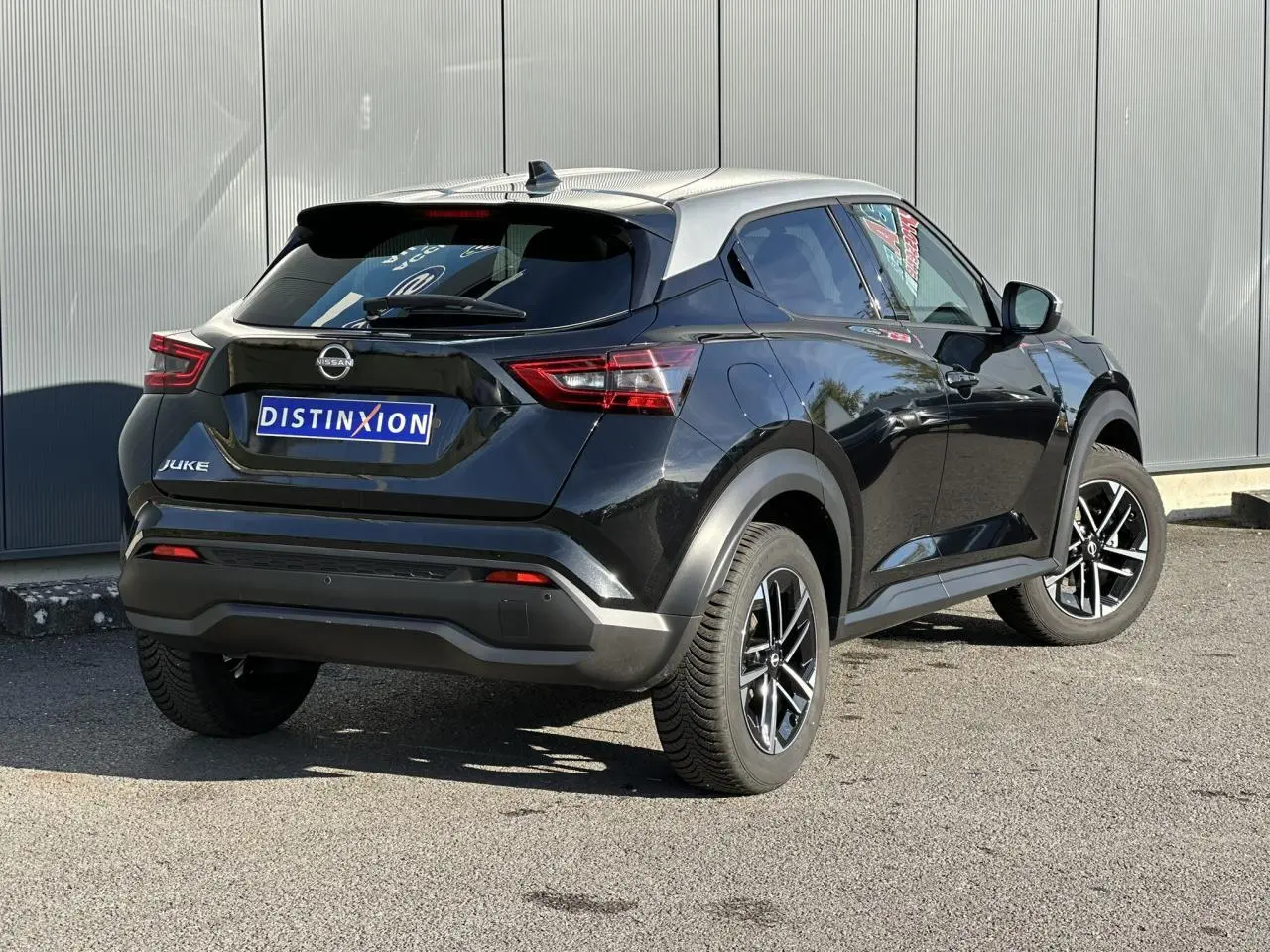 Vue 3/4 arrière droite du Nissan Juke noir avec toit gris et jantes alliage 17 pouces diamantées.
