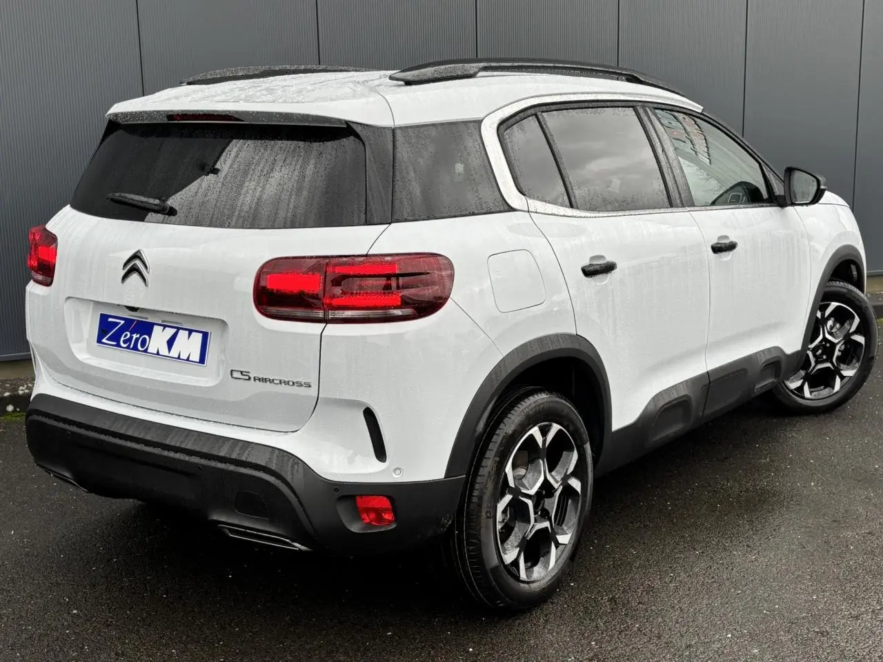 Vue 3/4 arrière droite d'un Citroën C5 Aircross blanc Okénite avec jantes alliage 18'' bi-ton et vitres surteintées.