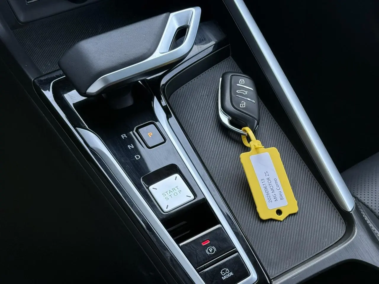Gros plan sur la console centrale avec levier de vitesse, bouton start/stop et clé du MG ZS Hybrid+ Bleu Como.