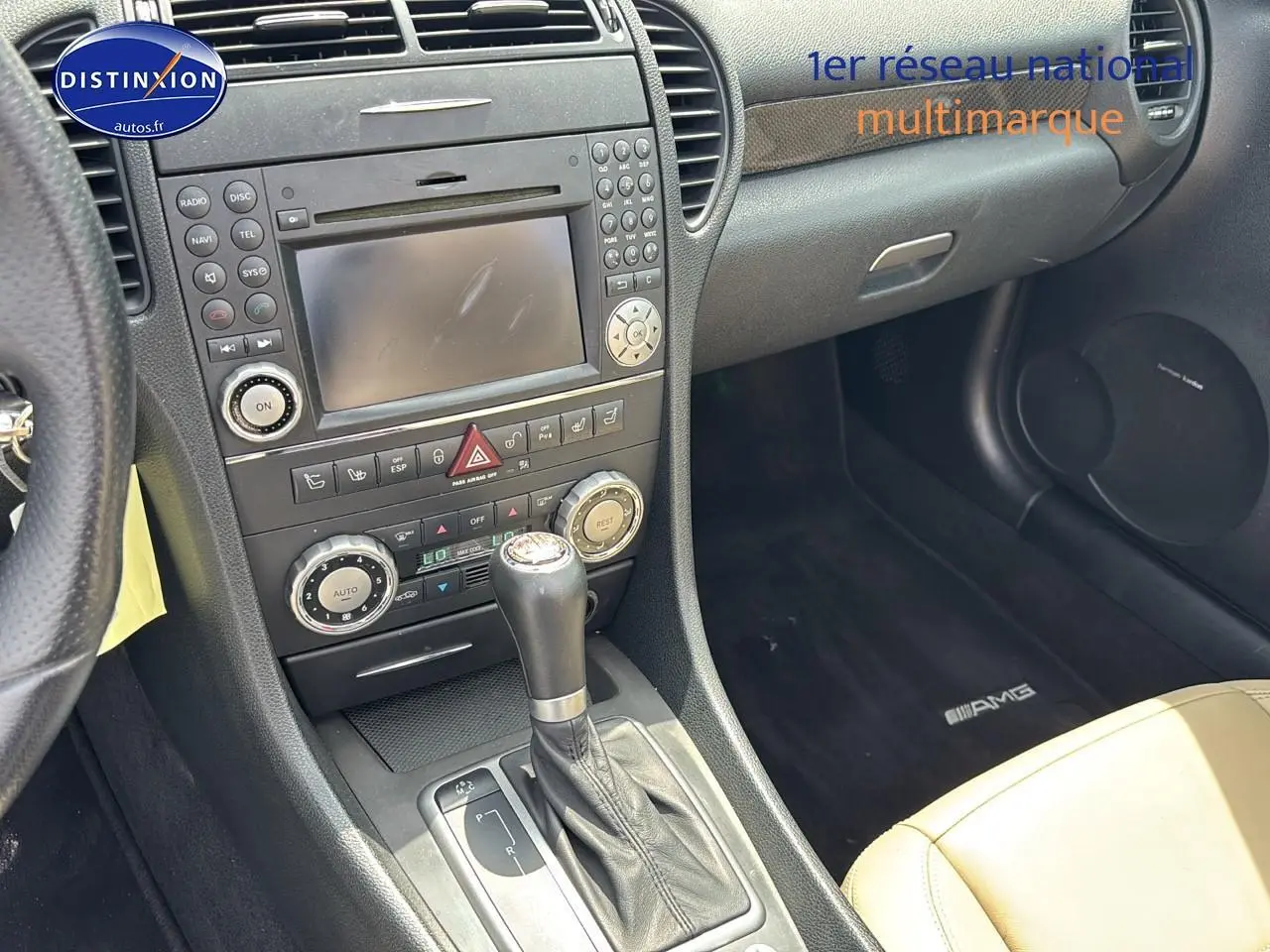 Intérieur côté passager d'une Mercedes SLK 55 AMG 2009, avec sellerie cuir beige et tapis AMG noir.