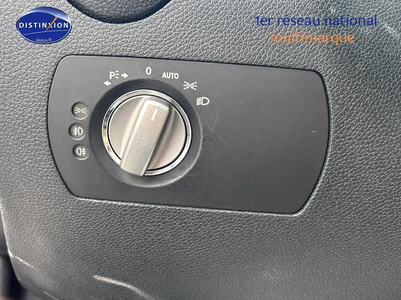 Gros plan sur le bouton de commande des phares sur tableau de bord noir d'une Mercedes SLK 55 AMG 7G-Tronic 2009.