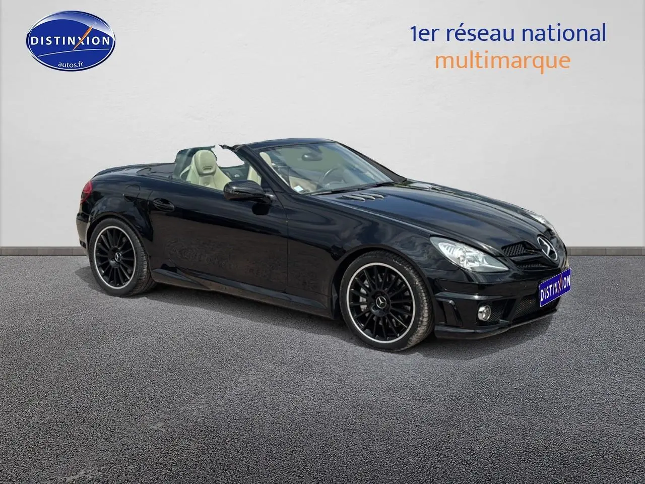 Mercedes SLK 55 AMG 7G-Tronic noire vue 3/4 avant droit, capote ouverte et jantes alliage noires sportives.