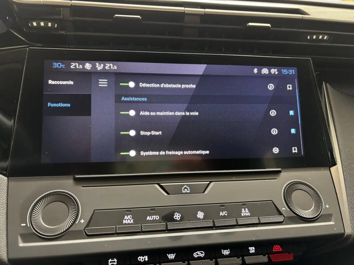 Écran tactile central affichant les aides à la conduite dans l'habitacle d'une Peugeot 308 vert 2022.
