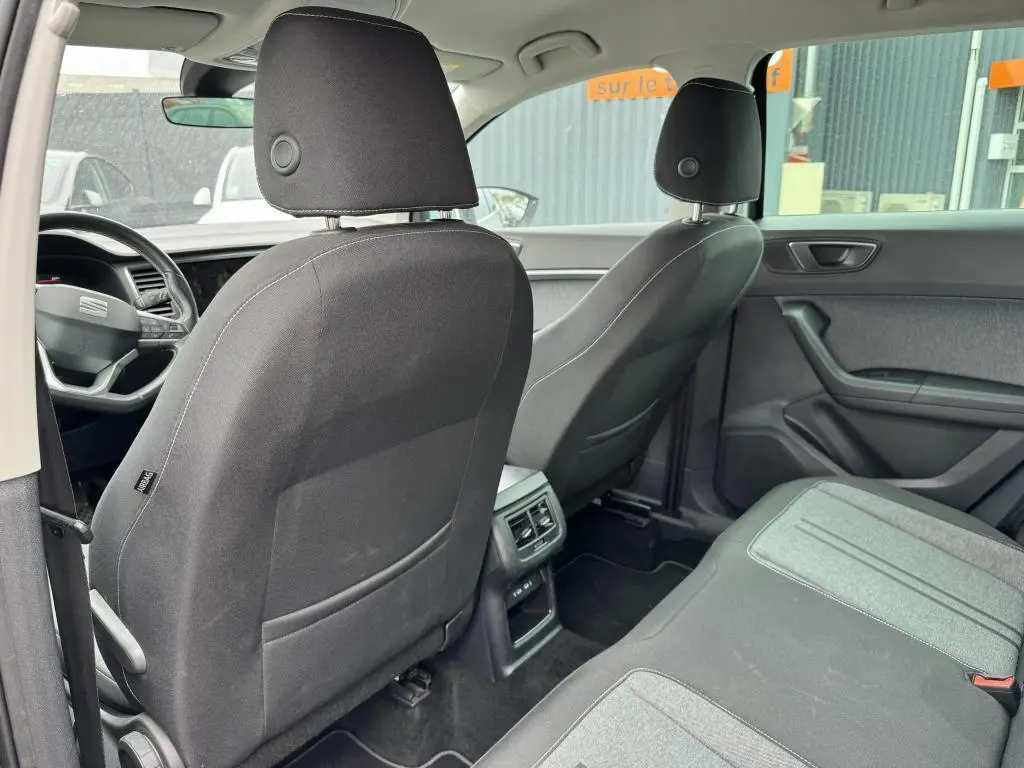 Vue arrière intérieure du SEAT Ateca 2023 avec sièges en textile noir et gris et console centrale avec prises USB-C.