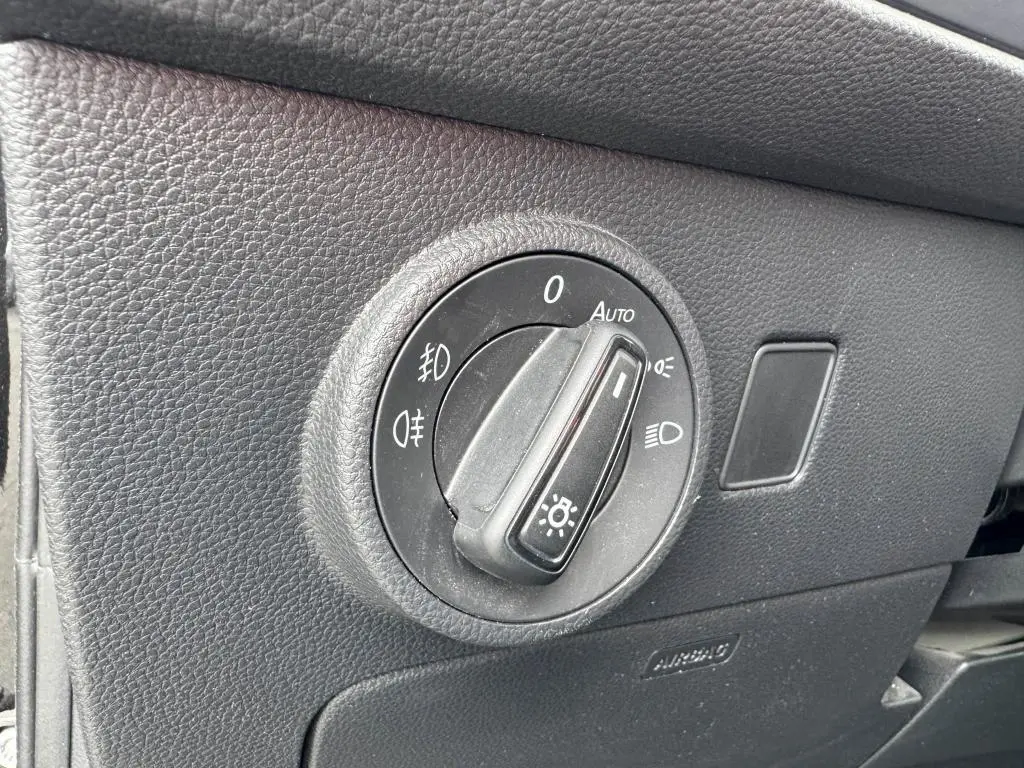 Gros plan sur le bouton de commande des phares dans l'habitacle noir du SEAT Ateca 2023 version Style.