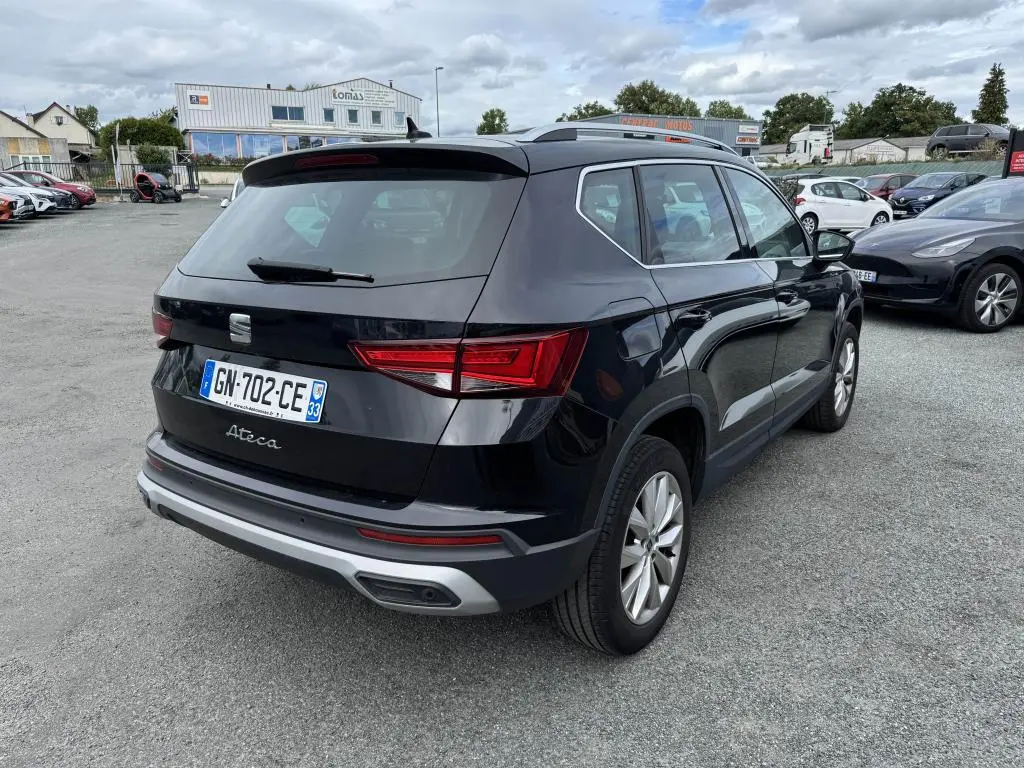 Vue 3/4 arrière droite d'un SUV SEAT Ateca noir métallisé avec feux arrière LED et jantes alliage 17 pouces.