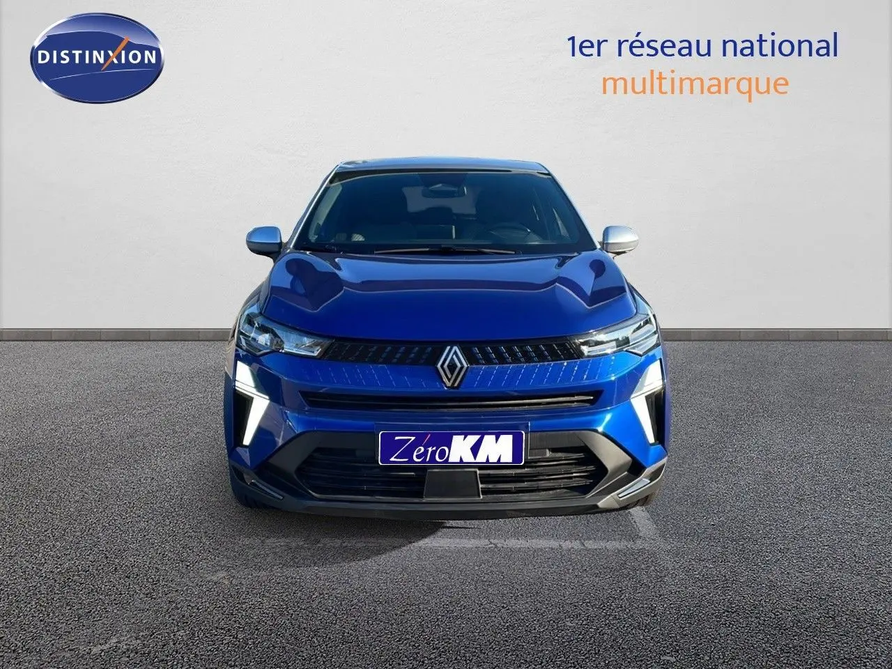Renault Captur E-Tech hybride bleu Iron métal, vue frontale avec toit gris et éclairage LED distinctif.