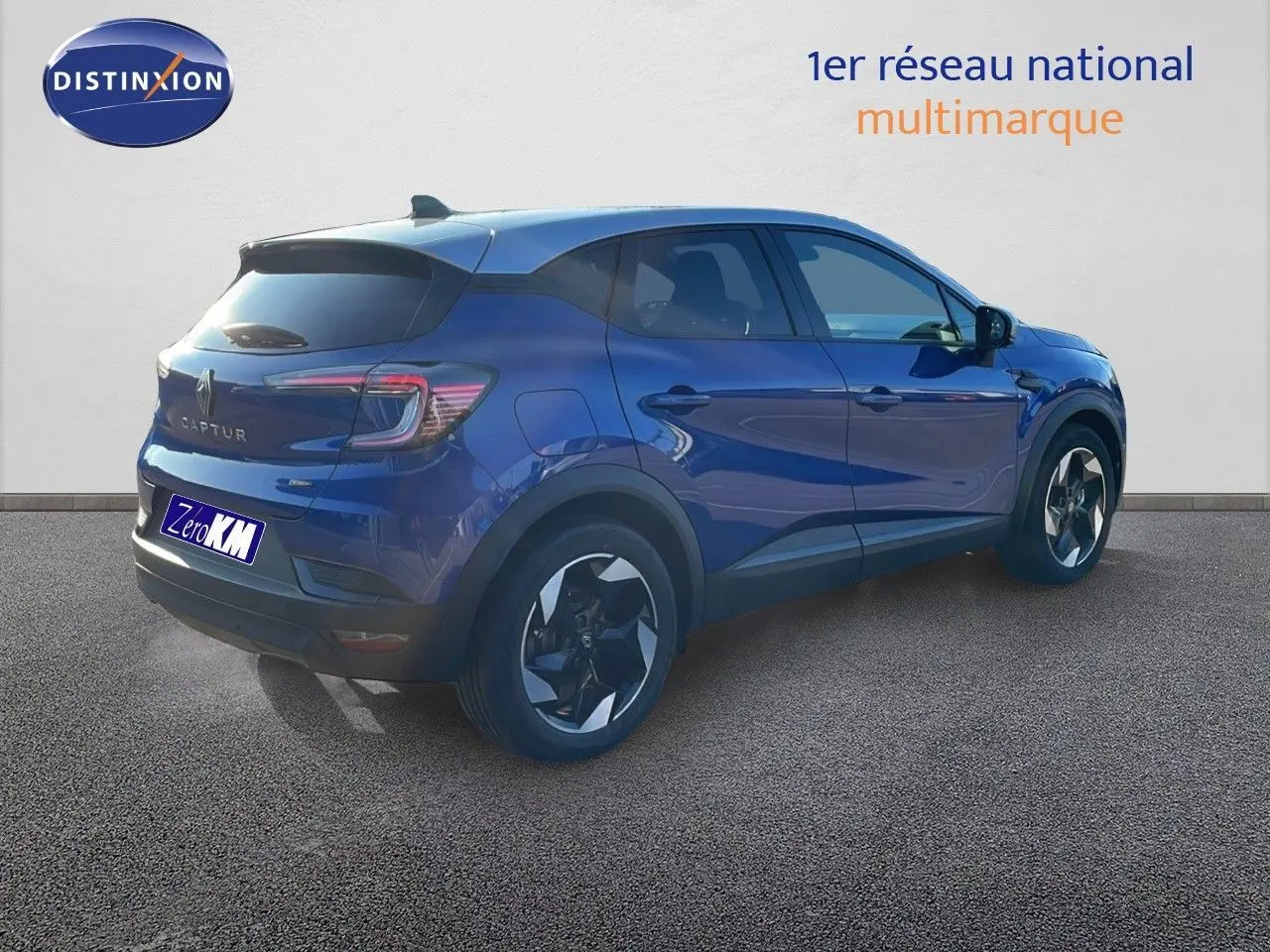 Renault Captur E-Tech hybride bleu Iron Metal avec toit gris, vue 3/4 arrière côté gauche sur sol gris.