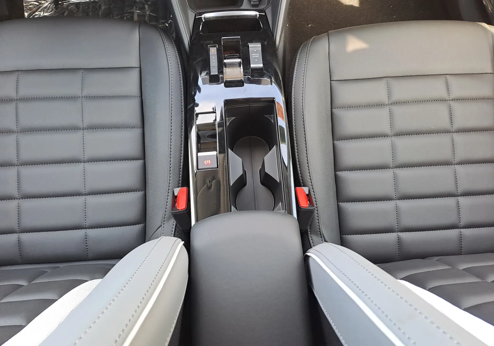 Vue plongeante sur la console centrale et sièges noirs en cuir du Citroën C4 hybride 2025 Manhattan Green.