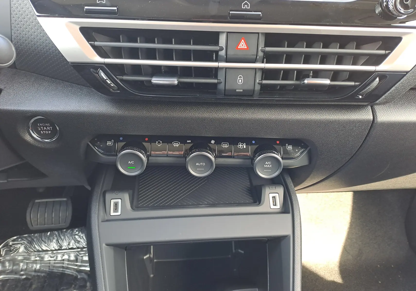 Tableau de bord de Citroën C4 hybride 2025, vue centrée sur commandes climatisation et bouton start/stop.