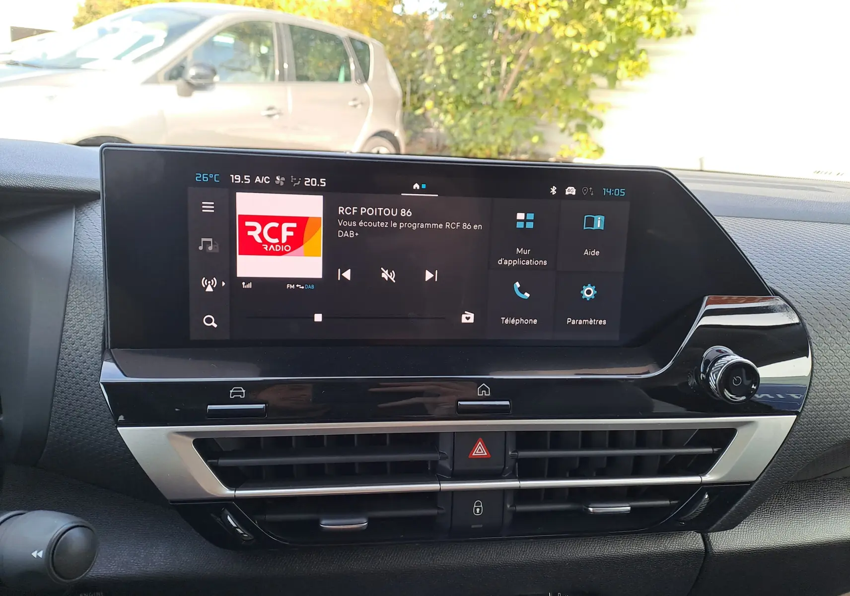 Écran tactile central du tableau de bord de la Citroën C4 hybride 2025 affichant la radio RCF, avec commandes et aérateurs visibles