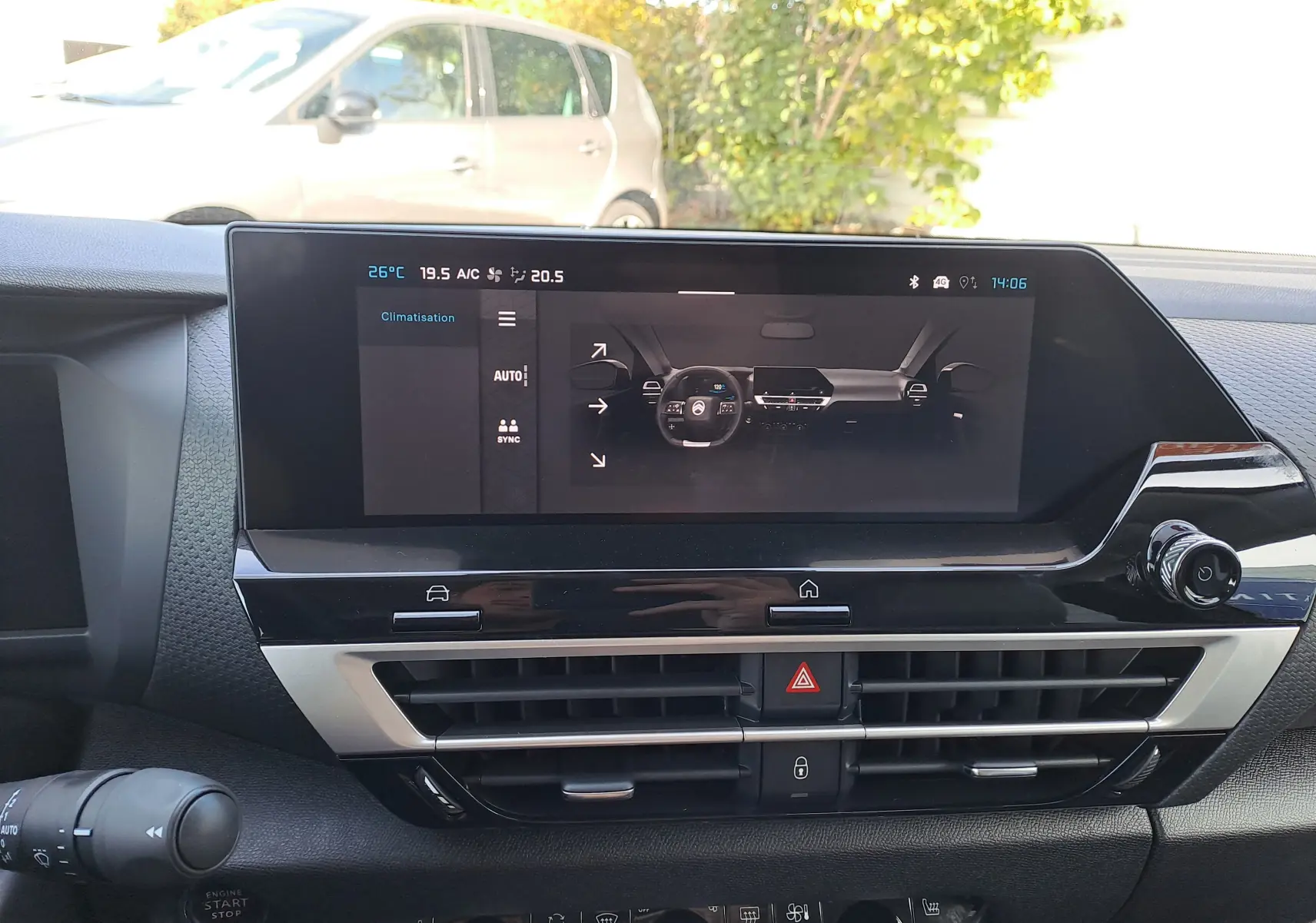 Tableau de bord de la Citroën C4 hybride 2025 avec écran tactile central et commandes de climatisation visibles.