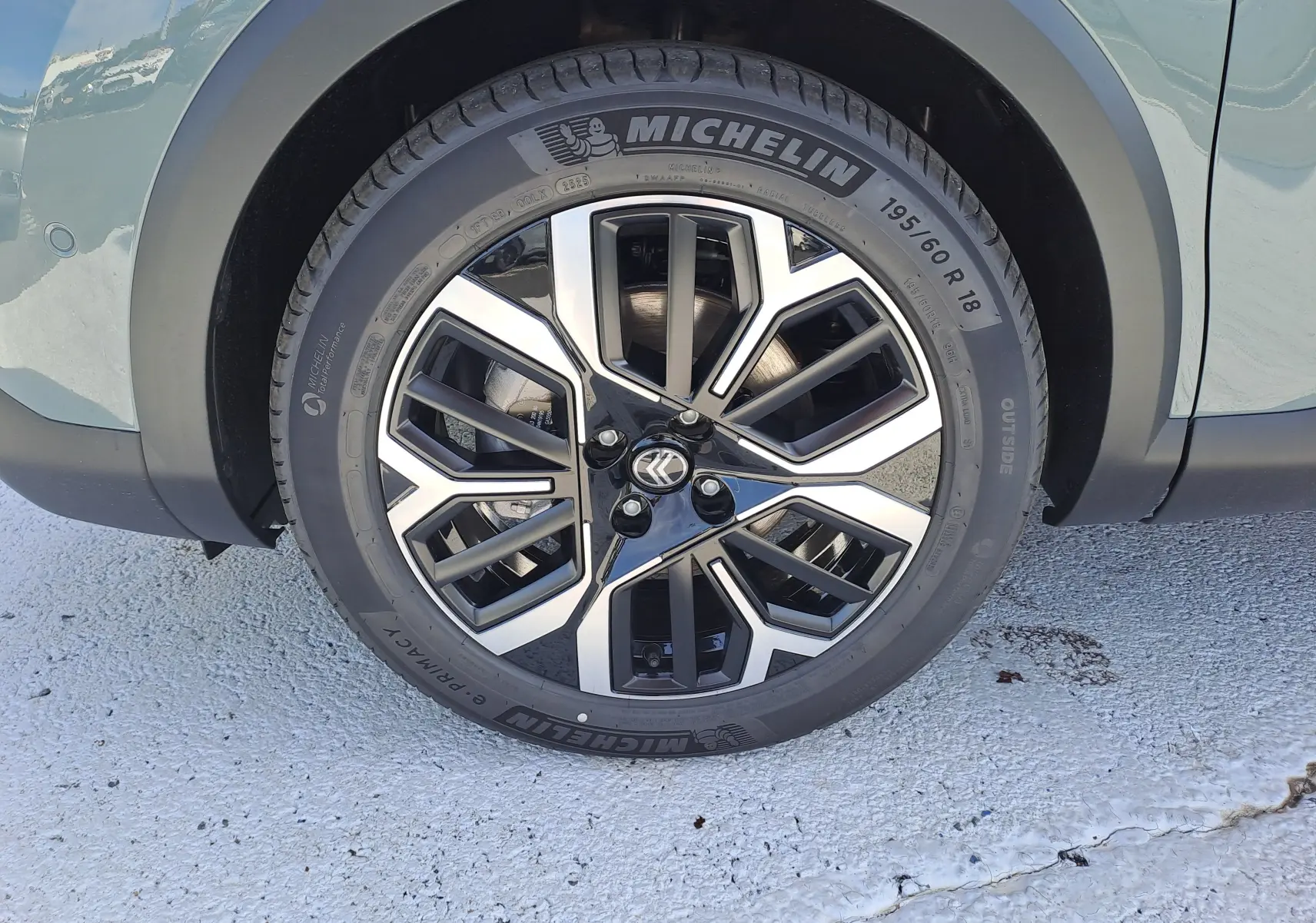 Gros plan sur la roue avant gauche de la Citroën C4 hybride 2025 Manhattan Green avec jante alliage noire et argent.