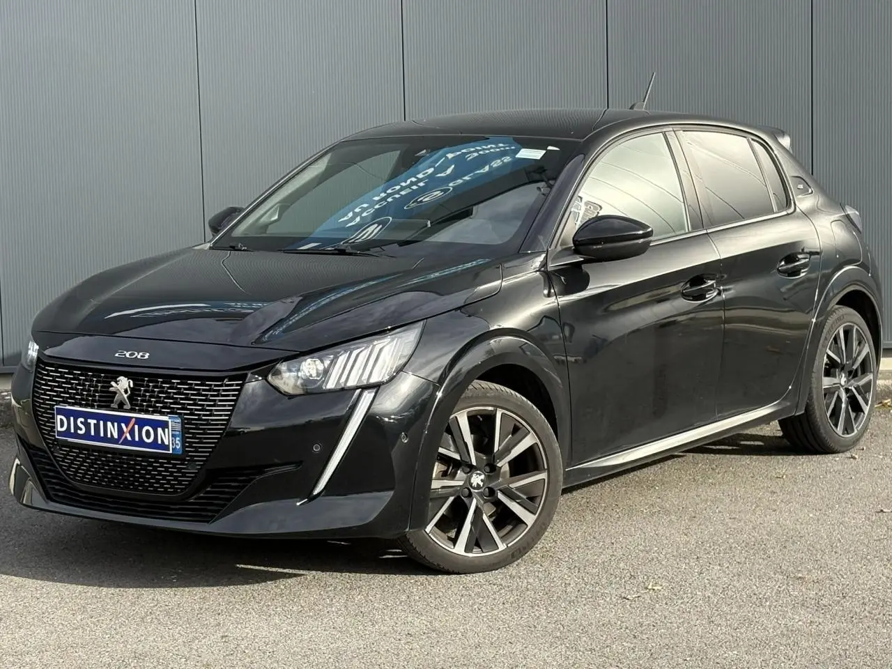 Peugeot 208 noir perla vue 3/4 avant droit avec jantes alliage et signature lumineuse LED verticale