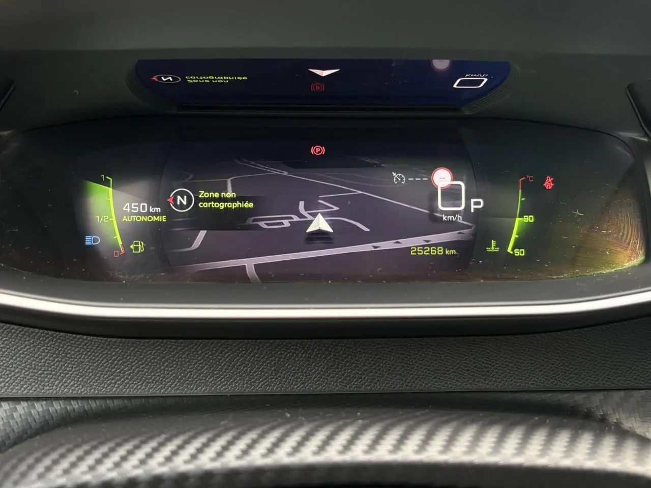 Affichage numérique du tableau de bord Peugeot 208 GT avec navigation 3D et indicateurs de vitesse et autonomie.