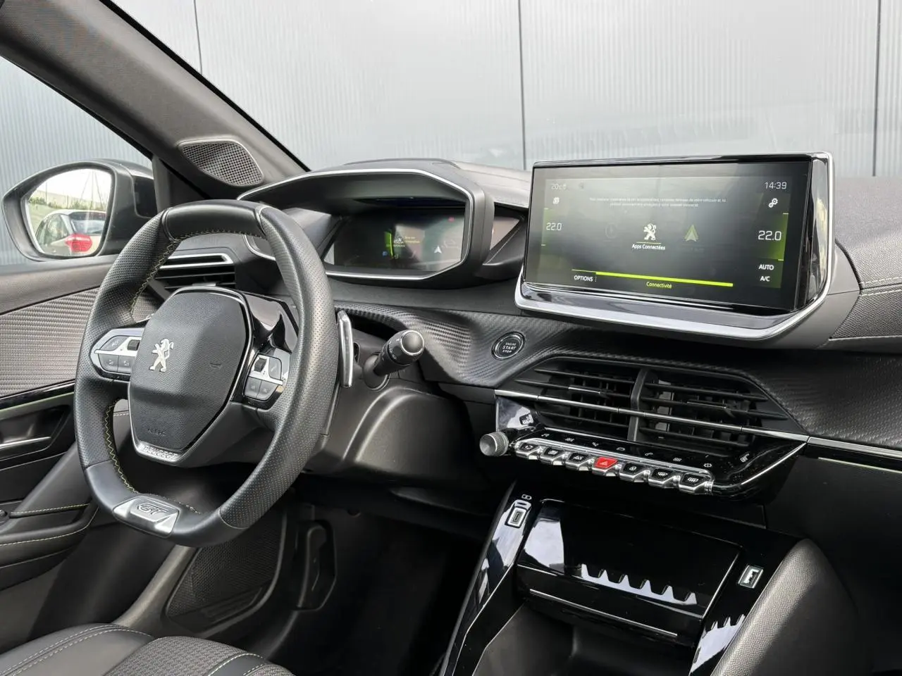 Intérieur avant gauche du Peugeot 208 GT noir Perla, volant compact cuir avec badge GT et écran tactile 10 pouces.