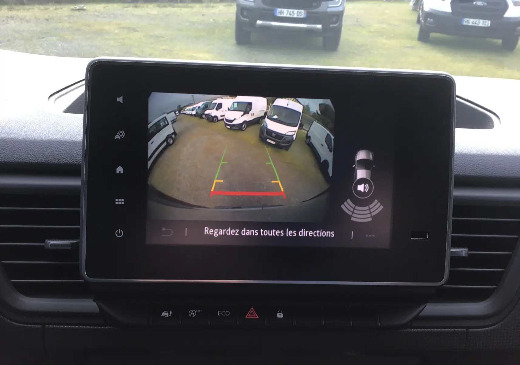 Écran tactile intérieur du Renault Trafic L2H1 2025 montrant la caméra de recul avec vue arrière et lignes de guidage colorées.
